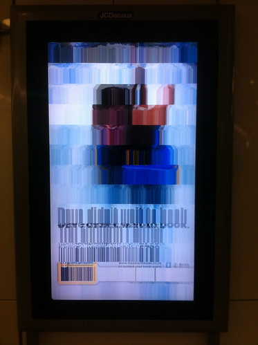Adverts via broken screen at Stratford station